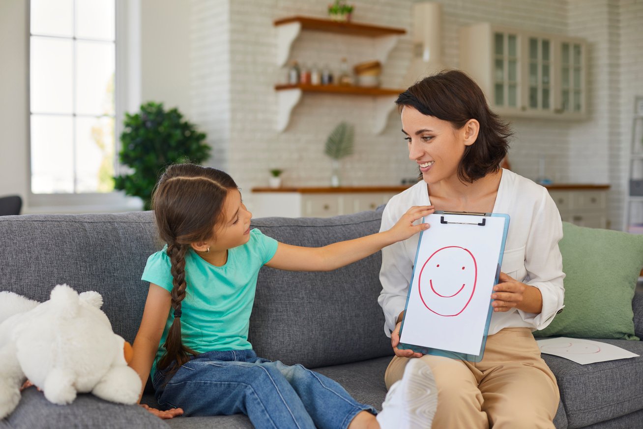 Private Therapist Talking to Curious Little Girl during Therapy Session at Home